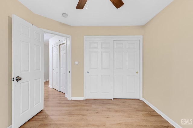 unfurnished bedroom with ceiling fan and light wood-type flooring