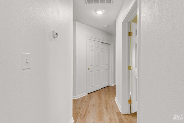 hallway with light hardwood / wood-style floors