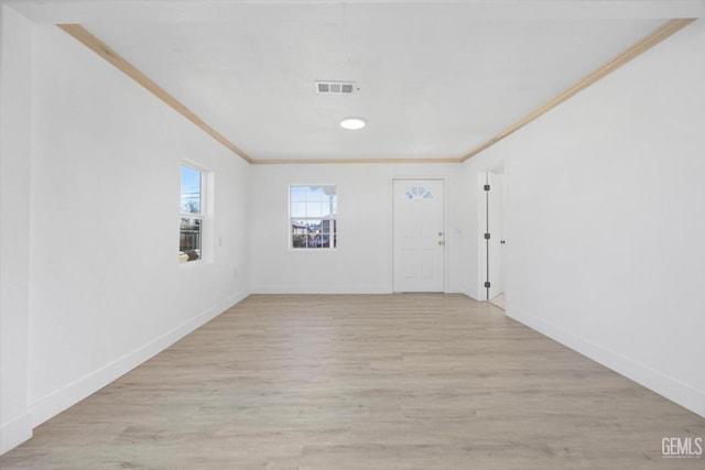 spare room featuring light hardwood / wood-style floors and crown molding