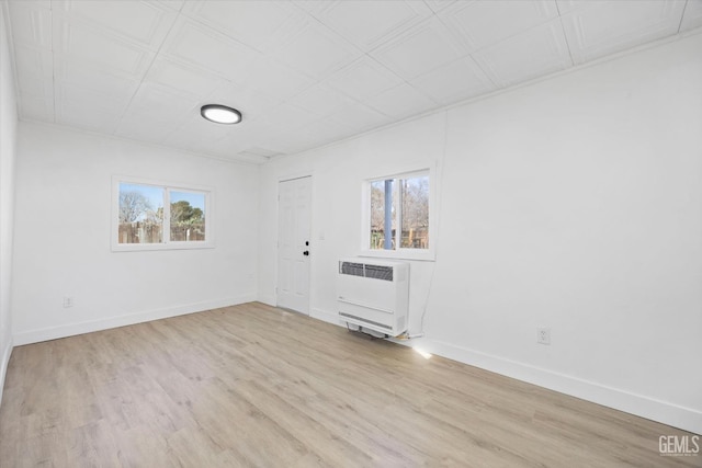 empty room with a healthy amount of sunlight, light hardwood / wood-style flooring, and heating unit