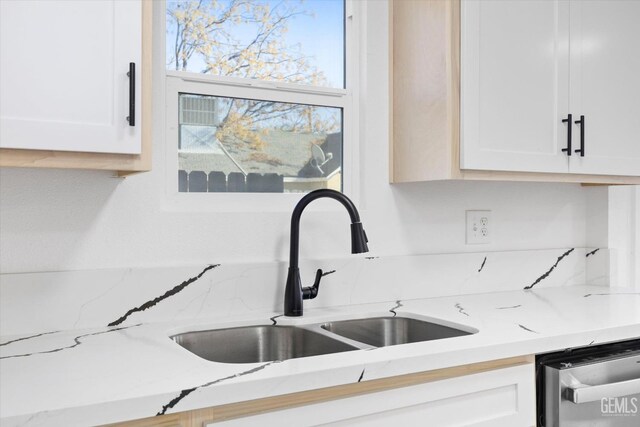 kitchen with white cabinets, stainless steel dishwasher, and sink