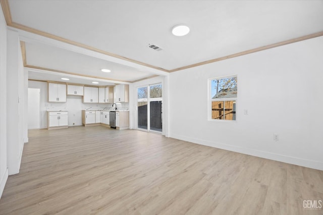 unfurnished living room featuring sink, light wood-type flooring, and crown molding