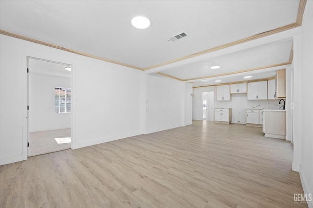 unfurnished living room with light wood-type flooring and crown molding