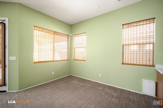 spare room featuring baseboards and carpet