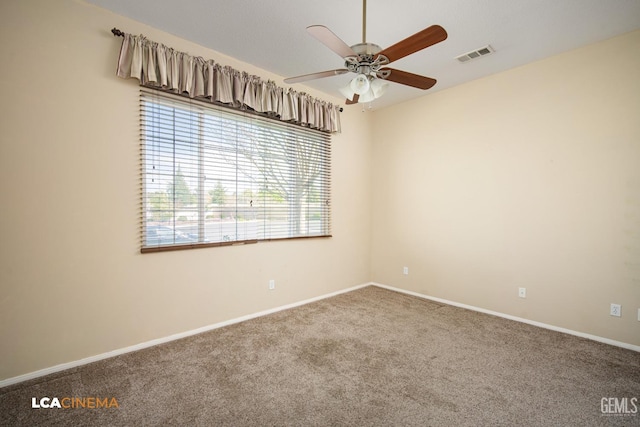 spare room featuring a ceiling fan, visible vents, carpet floors, and baseboards