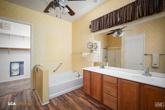 full bath featuring a stall shower, a jetted tub, wood finished floors, and wallpapered walls