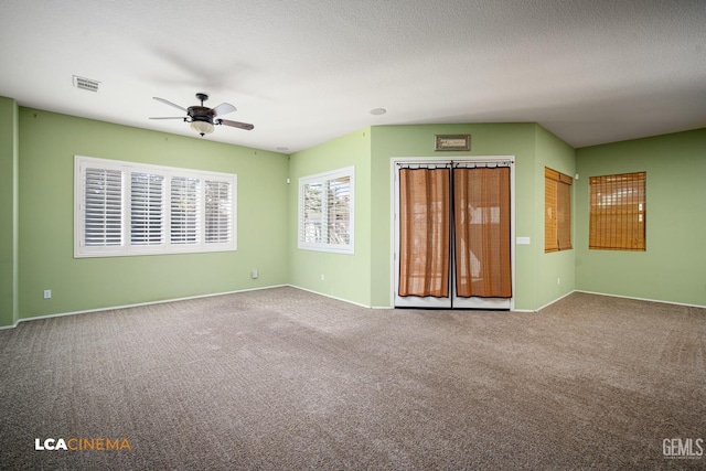 empty room featuring visible vents, a ceiling fan, a textured ceiling, carpet, and baseboards