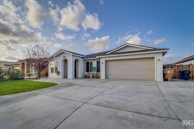 single story home featuring an attached garage, concrete driveway, a front yard, and fence