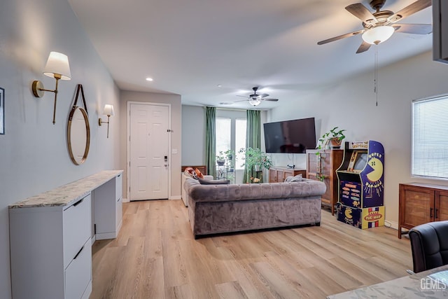 living area with recessed lighting, a ceiling fan, light wood-style floors, and baseboards