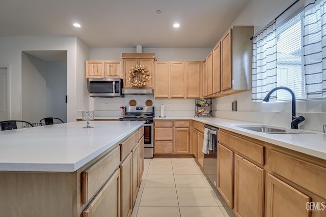 kitchen featuring light tile patterned floors, light brown cabinets, a sink, light countertops, and appliances with stainless steel finishes