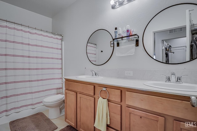 bathroom featuring a sink, visible vents, toilet, and double vanity