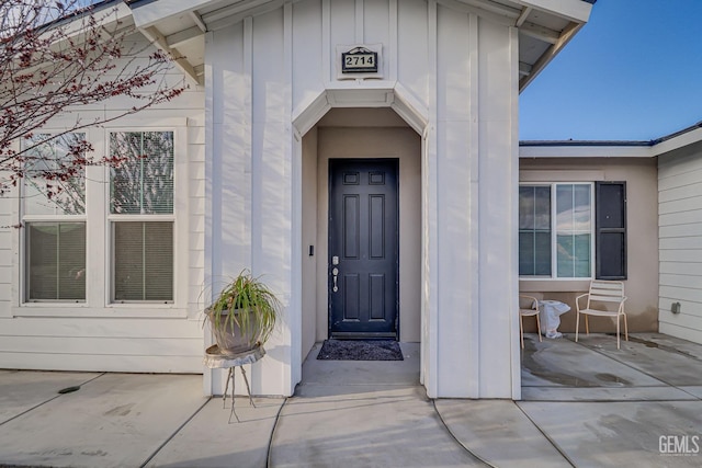 entrance to property featuring a patio area and board and batten siding