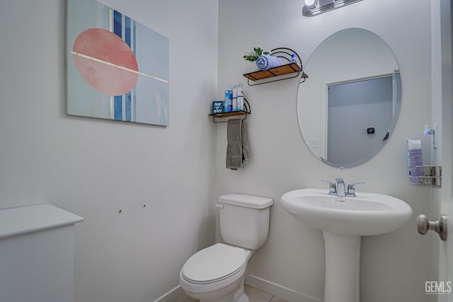 bathroom with a sink, baseboards, and toilet