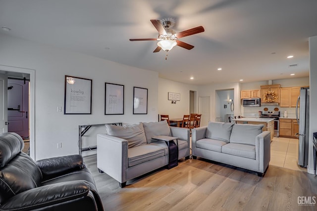 living room with light wood finished floors, visible vents, recessed lighting, and ceiling fan