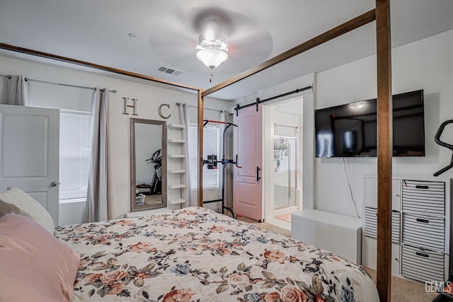 bedroom with a barn door and visible vents