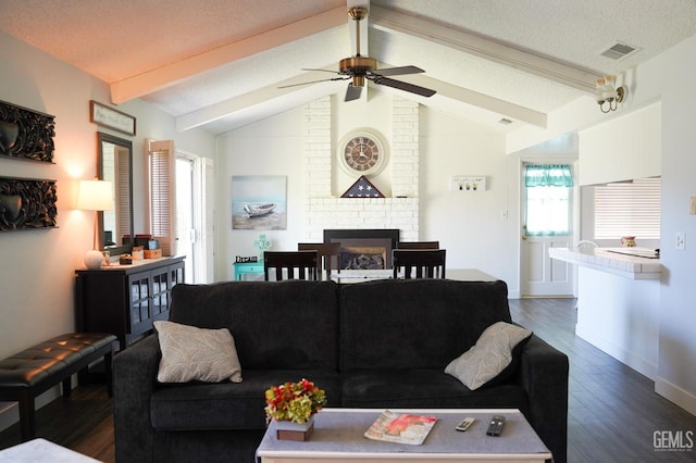 5421 Demaret Ave, Bakersfield, CA 93309 - living room featuring dark wood finished floors, a fireplace, a ceiling fan, and a textured ceiling