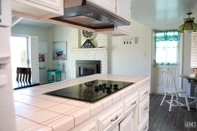 5421 Demaret Ave, Bakersfield, CA 93309 - kitchen with tile counters, black electric cooktop, ventilation hood, and white cabinetry