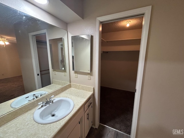 2626 Cleo Ct Unit 20, Bakersfield, CA 93306 - bathroom featuring vanity, a textured ceiling, and a walk in closet