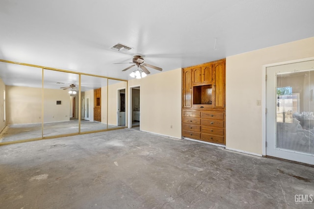 unfurnished bedroom featuring concrete floors, two closets, baseboards, and a ceiling fan