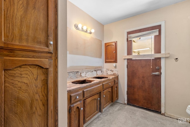 bathroom with vanity, concrete flooring, and toilet