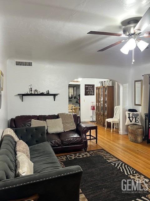 2320 Olympic Dr, Bakersfield, CA 93308 - living area featuring arched walkways, visible vents, wood finished floors, and a ceiling fan