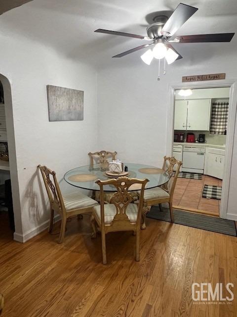 2320 Olympic Dr, Bakersfield, CA 93308 - dining room featuring arched walkways, light wood-style floors, and a ceiling fan