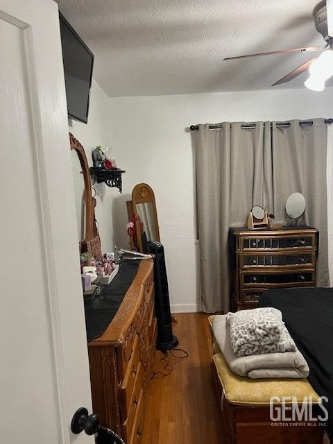 2320 Olympic Dr, Bakersfield, CA 93308 - bedroom with wood finished floors, ceiling fan, and a textured ceiling