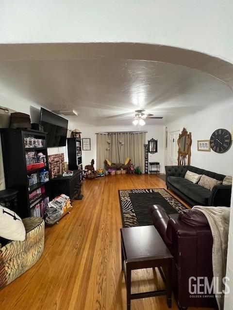 2320 Olympic Dr, Bakersfield, CA 93308 - living room featuring arched walkways, ceiling fan, and wood finished floors