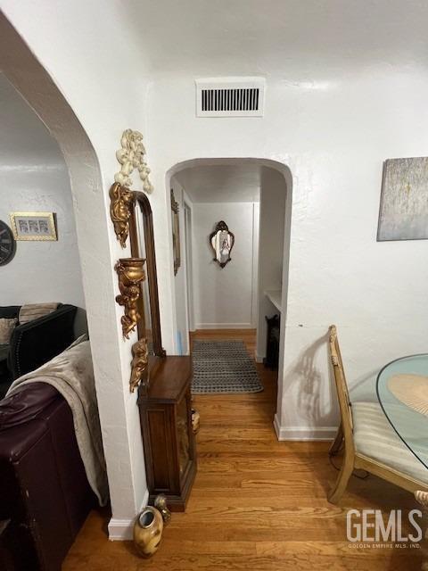 2320 Olympic Dr, Bakersfield, CA 93308 - corridor featuring light wood-type flooring, arched walkways, and visible vents