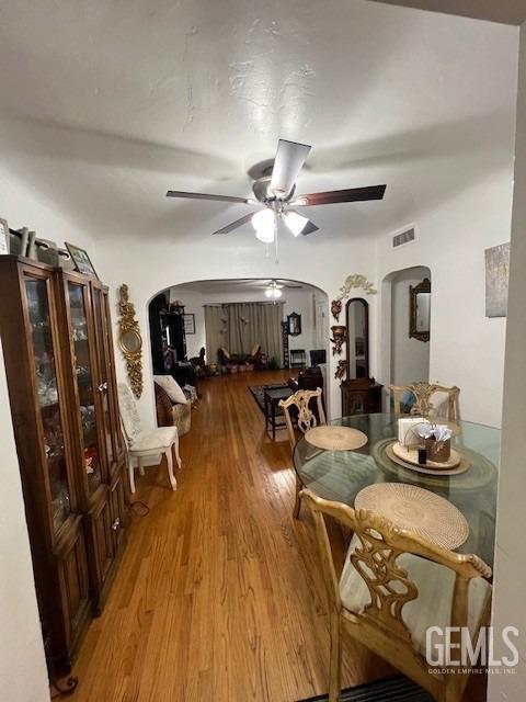 2320 Olympic Dr, Bakersfield, CA 93308 - dining space with light wood-style flooring, visible vents, arched walkways, and ceiling fan