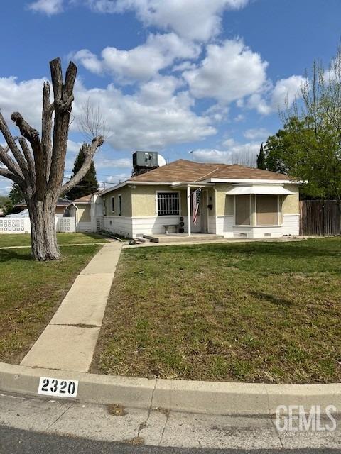 2320 Olympic Dr, Bakersfield, CA 93308 - bungalow-style home featuring cooling unit, fence, and a front lawn