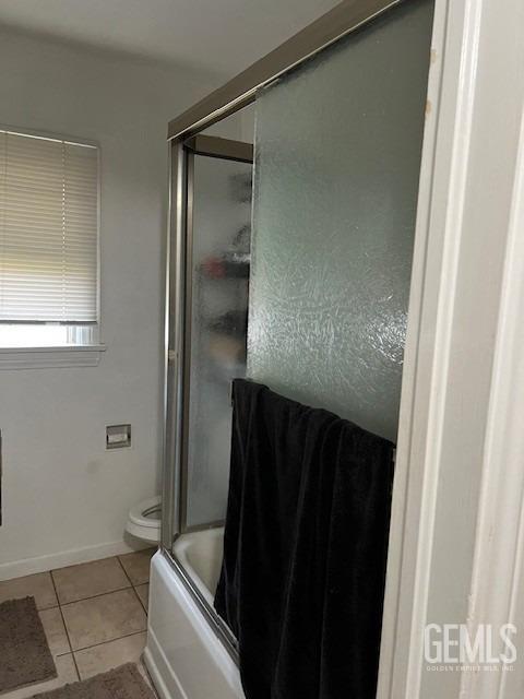 2320 Olympic Dr, Bakersfield, CA 93308 - full bathroom with tile patterned flooring, shower / bath combination with glass door, toilet, and baseboards