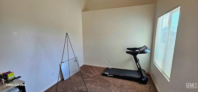 exercise room with dark colored carpet and baseboards