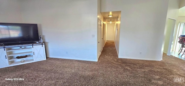 unfurnished living room featuring carpet floors and baseboards