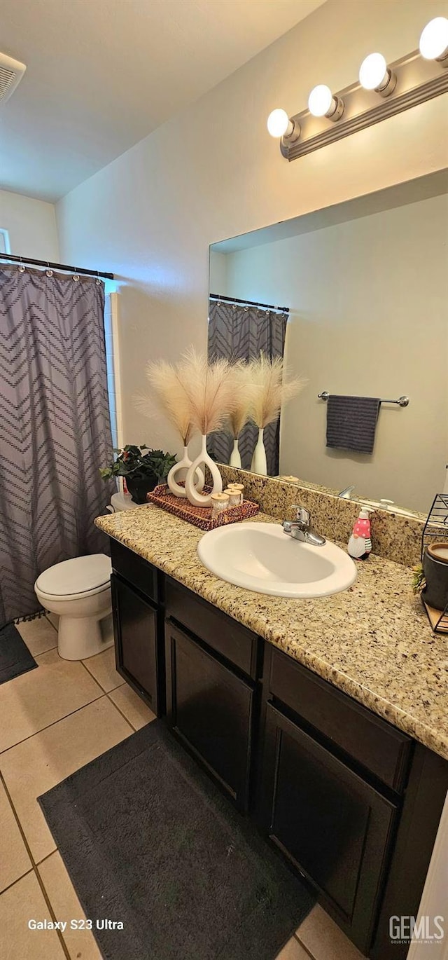 bathroom with visible vents, vanity, toilet, and tile patterned floors