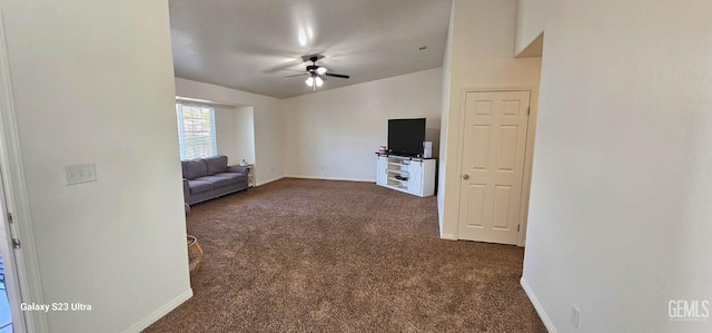 unfurnished living room with dark carpet, a ceiling fan, and baseboards