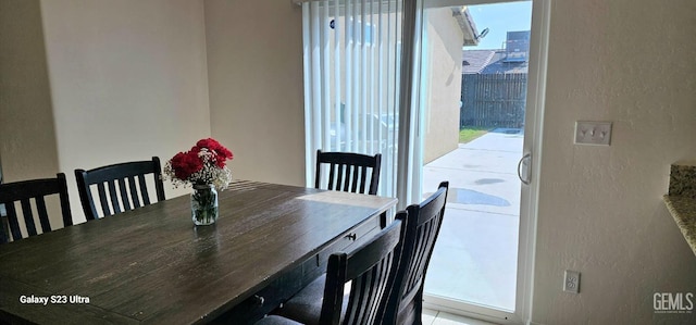 dining space featuring a healthy amount of sunlight and a textured wall