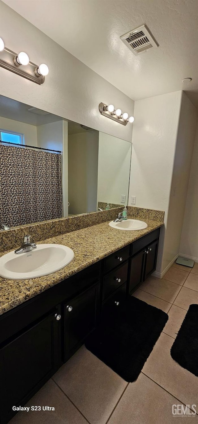 bathroom featuring double vanity, tile patterned flooring, a sink, and visible vents