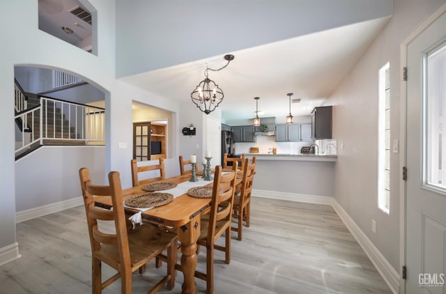 8315 Persimmon Dr, Bakersfield, CA 93311 - dining room with light wood-style floors, a chandelier, and stairs