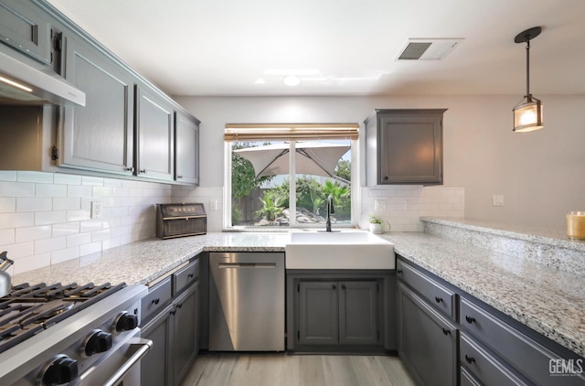 8315 Persimmon Dr, Bakersfield, CA 93311 - kitchen with stainless steel appliances, under cabinet range hood, tasteful backsplash, light wood-type flooring, and light stone countertops