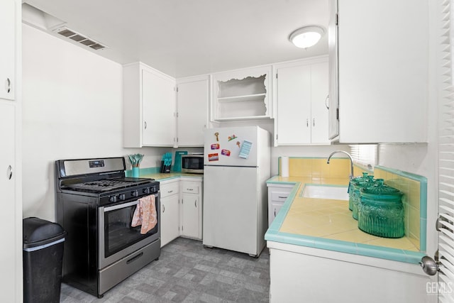 324 Western Dr, Bakersfield, CA 93309 - kitchen with stainless steel appliances, open shelves, white cabinets, tile countertops, and a sink