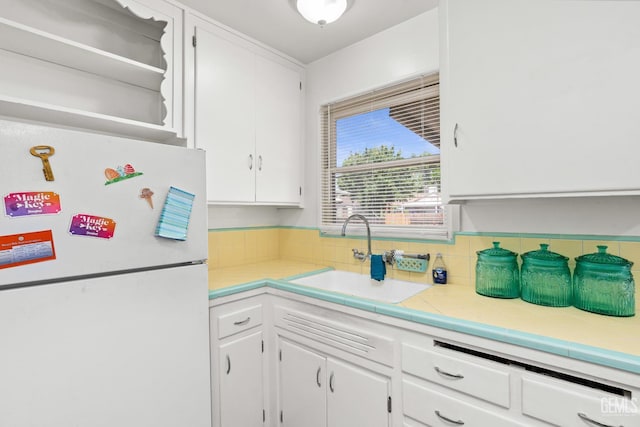 324 Western Dr, Bakersfield, CA 93309 - kitchen with freestanding refrigerator, a sink, white cabinets, decorative backsplash, and tile countertops