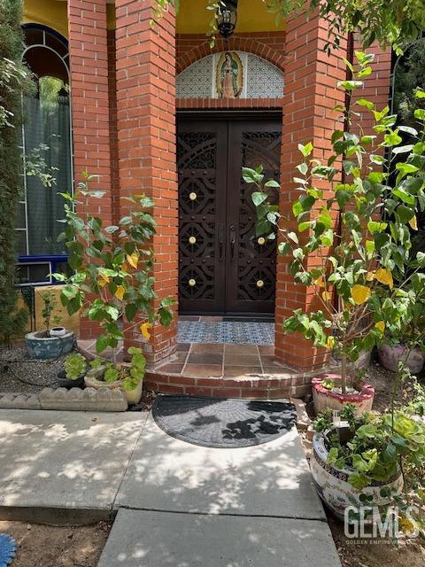 entrance to property featuring brick siding and french doors