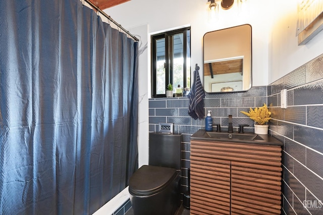 bathroom featuring walk in shower, vanity, toilet, and tile walls