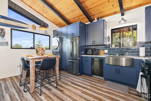 kitchen with sink, stainless steel fridge, backsplash, lofted ceiling with beams, and blue cabinets