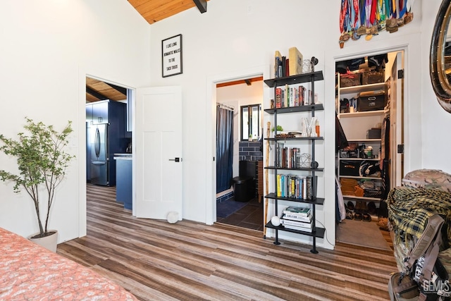 bedroom featuring ensuite bathroom, high vaulted ceiling, wooden ceiling, stainless steel fridge, and dark hardwood / wood-style flooring