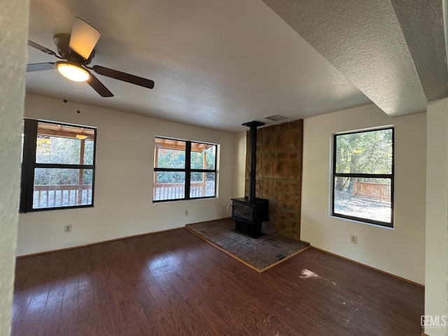 unfurnished living room featuring visible vents, a textured ceiling, wood finished floors, and a healthy amount of sunlight