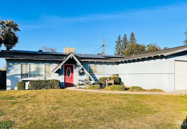 view of front of house with a front lawn and solar panels