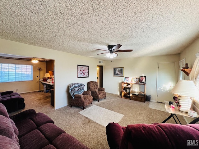 carpeted living room featuring a textured ceiling and ceiling fan