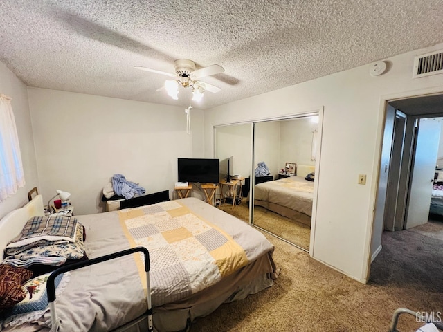 carpeted bedroom featuring a closet, ceiling fan, and a textured ceiling